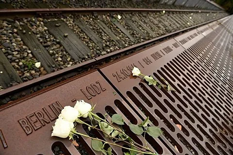 Gedenkstätte, Inschrift, weiße Rosen.