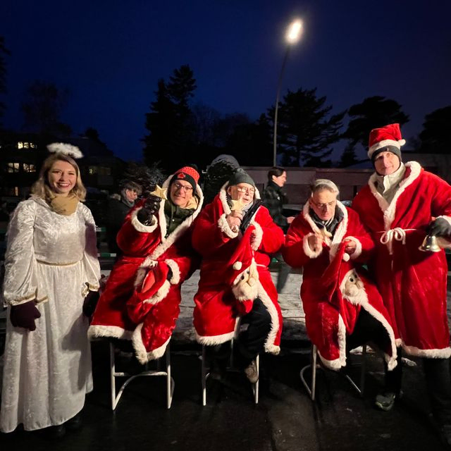 Weihnachtsmänner und Engel posieren