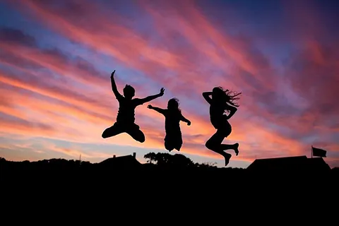 Silhouetten, springende Menschen, Sonnenuntergang.